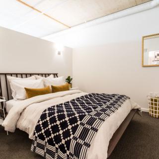 A modern and cozy bedroom with minimalist design featuring a neatly made bed and stylish decor.
