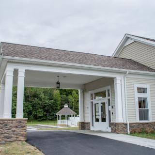 A welcoming entrance to a modern residential building on a cloudy day.
