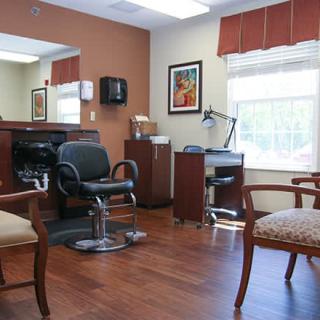A well-furnished hair salon with barber chairs, mirrors, and a waiting area.