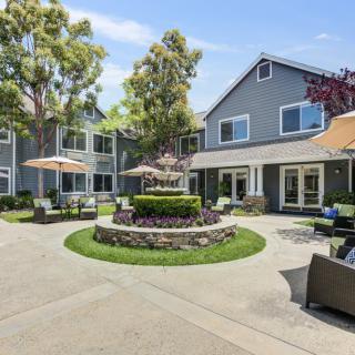 A charming residential courtyard with a central fountain and outdoor seating.