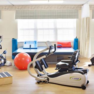 A well-equipped indoor gym with various fitness and rehabilitation equipment.