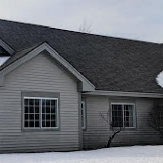 A cozy house covered in snow during winter.