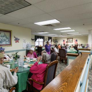 A lively gathering of seniors enjoying a communal meal in a welcoming dining area.