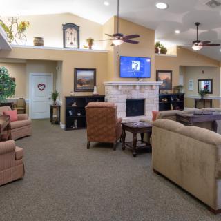 A cozy living room with comfortable seating, a television, and a fireplace.