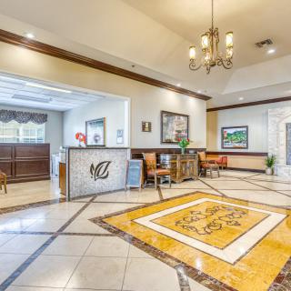 Elegant hotel lobby with a reception desk and seating area.