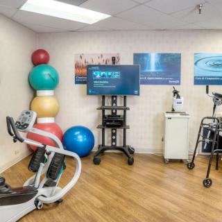 A physical therapy room equipped with exercise equipment and fitness balls.