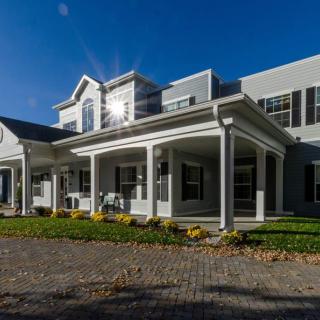 A modern residential house with a spacious front porch under bright sunlight.