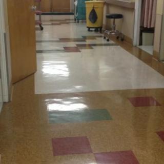 A clean hospital corridor with tiled flooring.