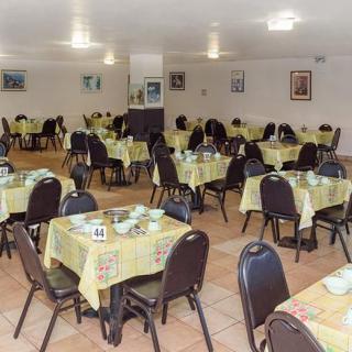An empty restaurant dining area with tables set for service.