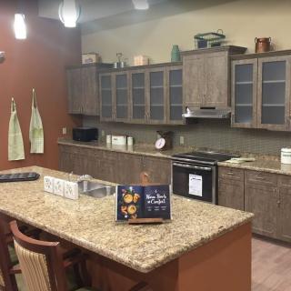 A modern kitchen with granite countertops and wooden cabinets.