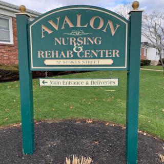 Sign for Avalon Nursing & Rehab Center with directional arrow.