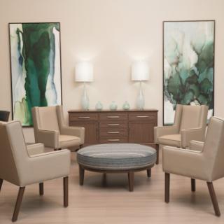 A stylish seating area featuring modern chairs, a round table, and elegant wall art.