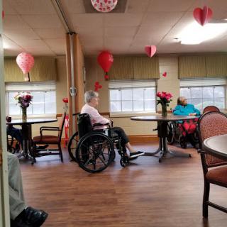 Residents enjoying their time in a decorated common area of an assisted living facility.