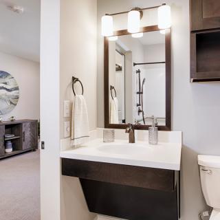 A modern bathroom with a stylish sink, illuminated mirror, and contemporary decor.