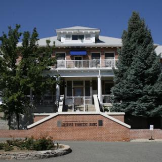 A well-designed building with a welcoming entrance, surrounded by trees under a clear blue sky.