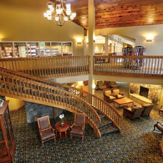 A welcoming hotel lobby featuring elegant wooden architecture and a cozy seating area.