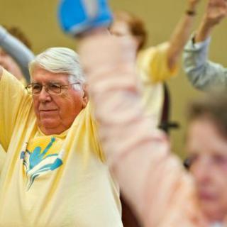 A group of senior citizens participating in a fitness class, engaging in an exercise routine.