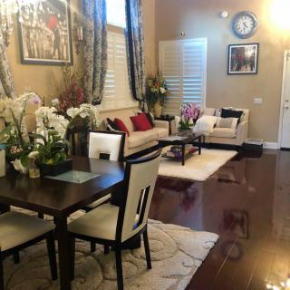 A stylish living and dining area with elegant decor and warm lighting.