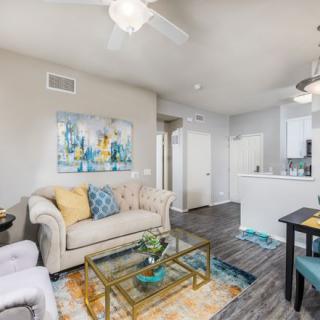 A modern living room featuring stylish furniture and decor, with a comfortable sofa and vibrant artwork.