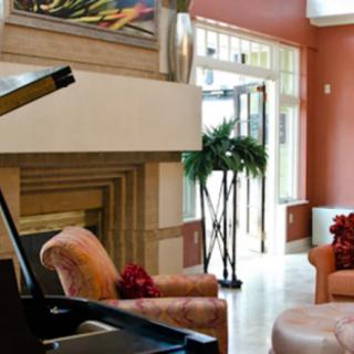 A cozy living room with a grand piano and stylish furnishings.