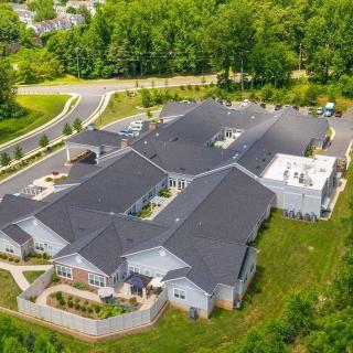 Aerial view of a large building complex surrounded by greenery and roads.