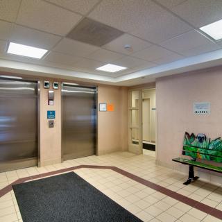 A building lobby with elevators and a small waiting area.