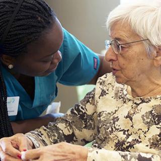 A caregiver assisting an elderly woman.