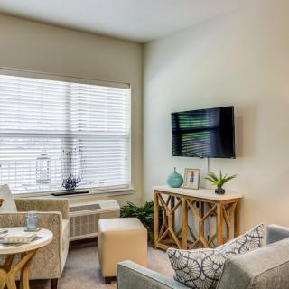 A cozy modern living room with comfortable seating and a mounted TV.