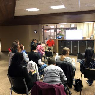 A group of people attending a presentation or meeting indoors.
