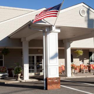 The entrance of a building with an American flag displayed.