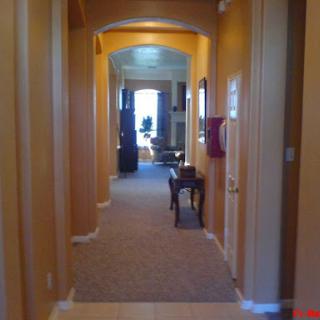 A warm, inviting hallway leading to a well-lit room.
