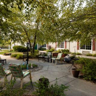 A tranquil garden setting with outdoor seating and lush greenery.