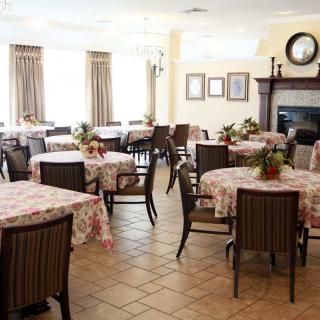 A bright and inviting dining room with floral tablecloths and neatly arranged tables.