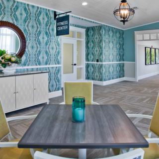 A stylish lobby area featuring a table with chairs, modern decor, and a decorative chandelier.