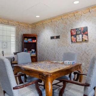 A small conference room with a wooden table and upholstered chairs, decorated with artwork on the walls.