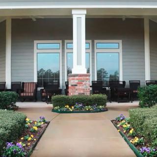 A well-maintained garden patio with symmetrical flower beds and outdoor seating.