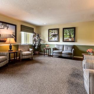 A cozy living room with comfortable seating, warm lighting, and decorative wall art.