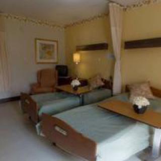 A hospital room with two beds and medical equipment.