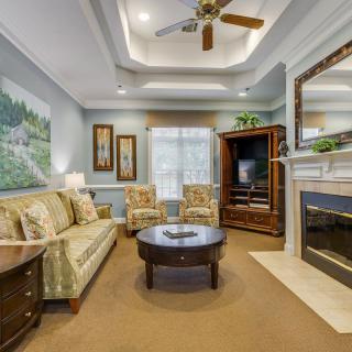 A cozy living room with a comfortable sofa, armchairs, and a fireplace, featuring elegant interior design elements.