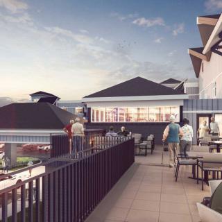A scenic rooftop with people enjoying outdoor seating amidst a picturesque evening skyline.