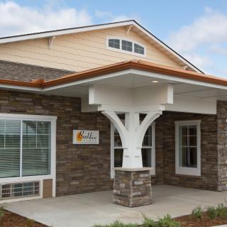 A modern building entrance with a stone facade and large windows.
