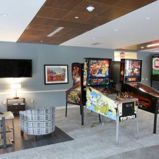 A recreational room featuring multiple pinball machines and a seating area.