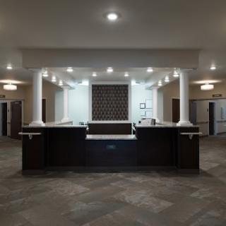 A modern hotel lobby featuring a sleek reception desk and elegant lighting.