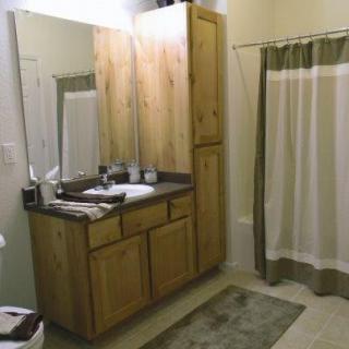 A well-organized bathroom with a wooden vanity and a shower curtain.