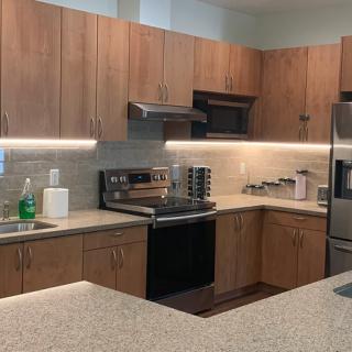 A modern kitchen with wood cabinets and stainless steel appliances.