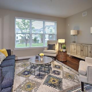 A modern and cozy living room with stylish furniture and a large window.