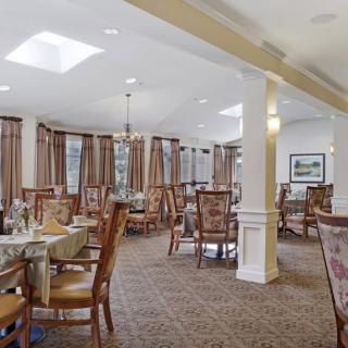 A spacious and elegantly decorated dining room with neatly arranged tables and chairs.