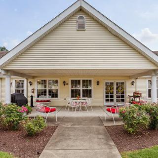 A suburban house with a spacious patio and outdoor seating area, surrounded by a well-maintained garden.