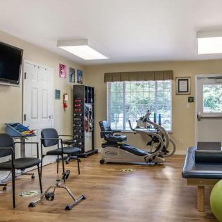 A physical therapy room equipped with exercise machines and seating.