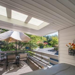 A cozy patio with outdoor seating under a skylight, complemented by a garden view.